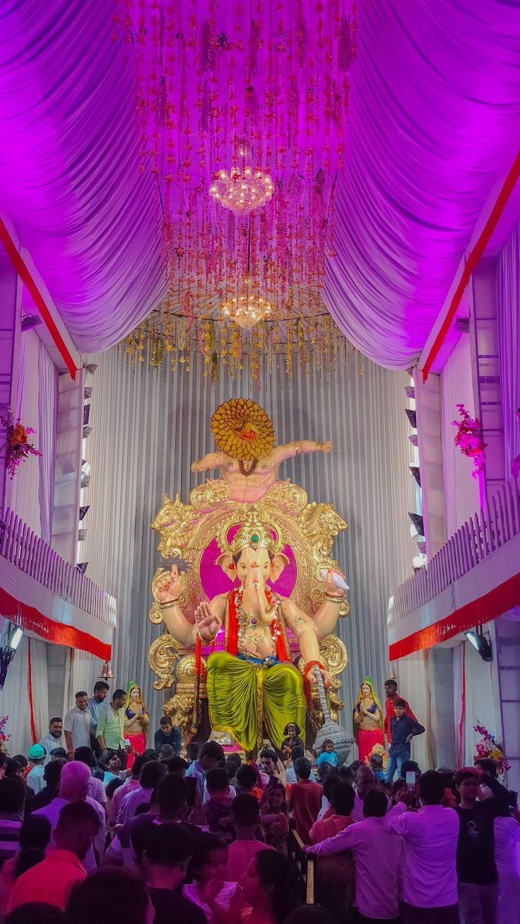 an idol is displayed in the middle of a large room with purple lights and chandeliers