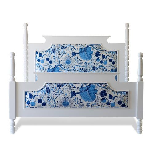 a blue and white bed frame with flowers on the top, two posts at the foot