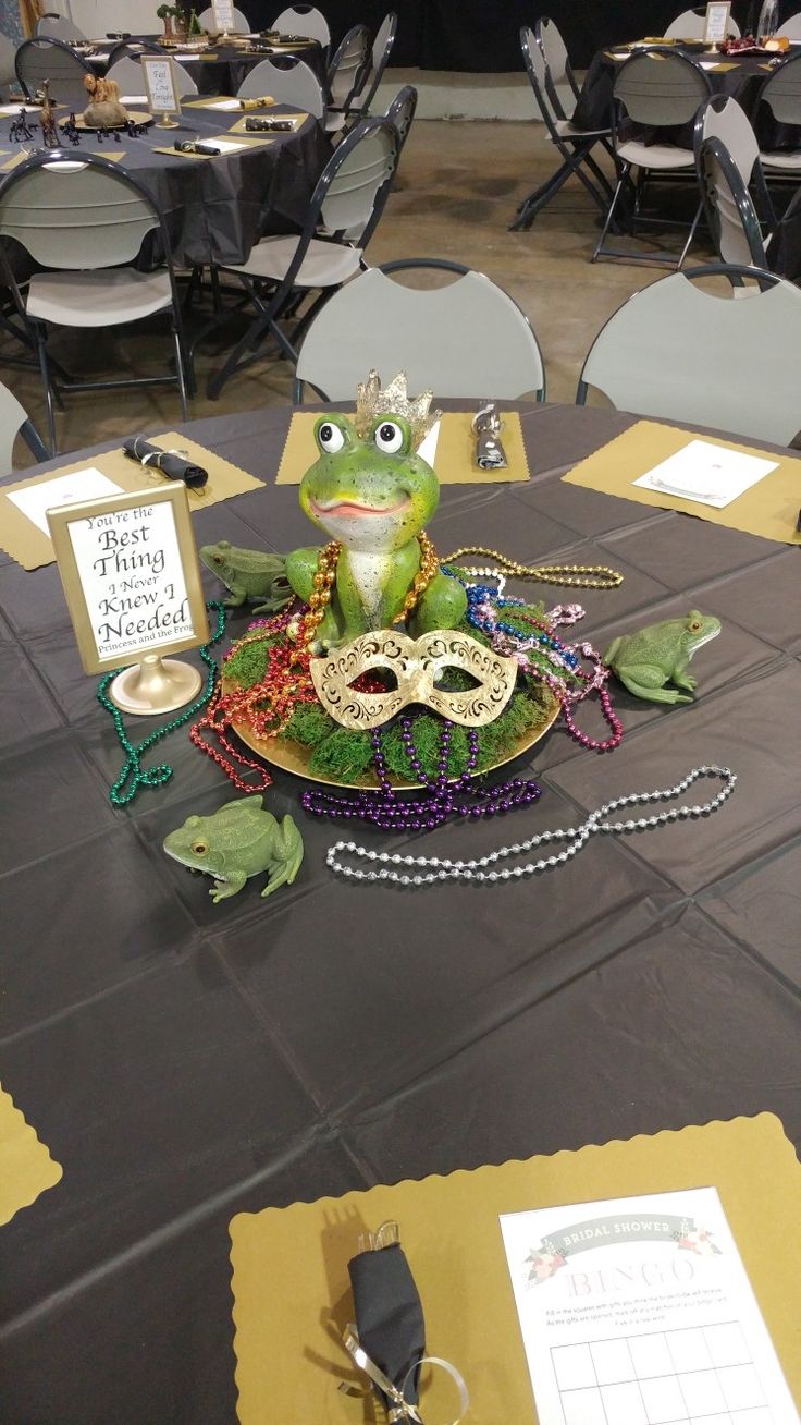 there is a frog sitting on top of a plate at the table with masks around it