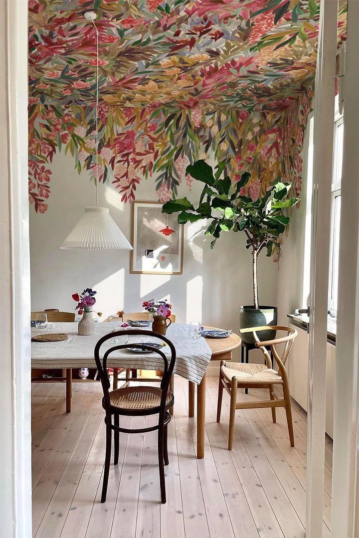 a dining room filled with lots of furniture and flowers hanging from the ceiling above it