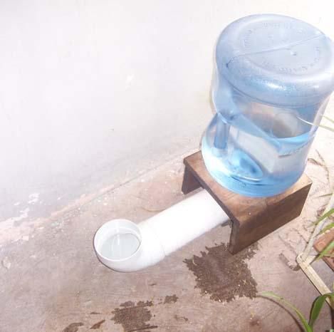 a water dispenser sitting on the ground next to a potted plant