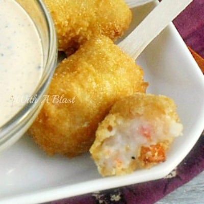 two fried food items on a plate with dipping sauce