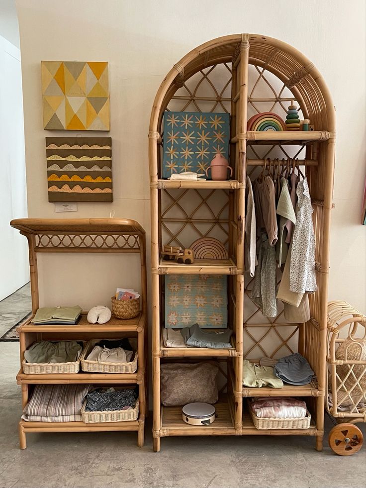 a bamboo shelf with baskets and clothes on it