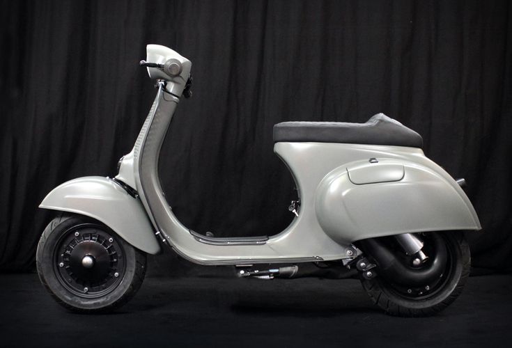 a white scooter parked in front of a black background