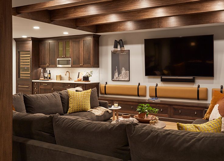 a living room filled with furniture and a flat screen tv mounted on the wall above it