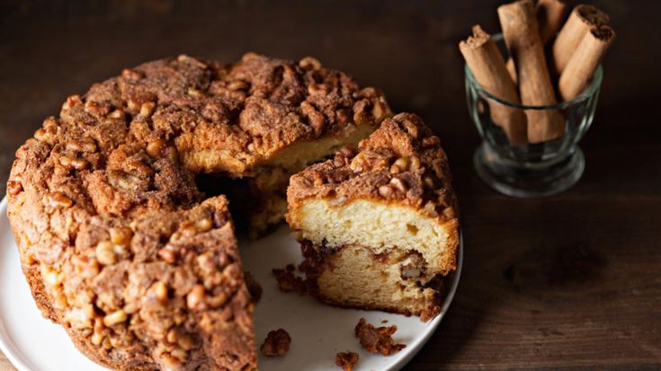 a bundt cake on a plate next to some cinnamon sticks