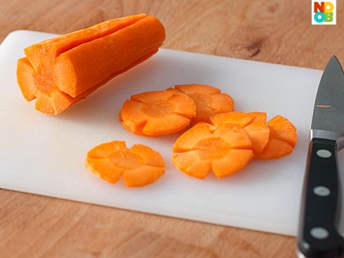 peeled carrots are on a cutting board next to a knife