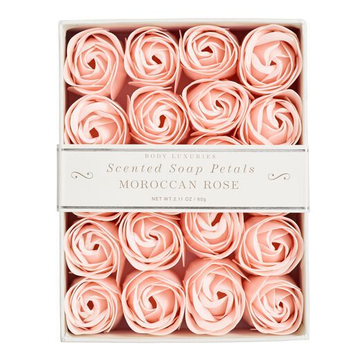 a box filled with pink rolled roses on top of a table