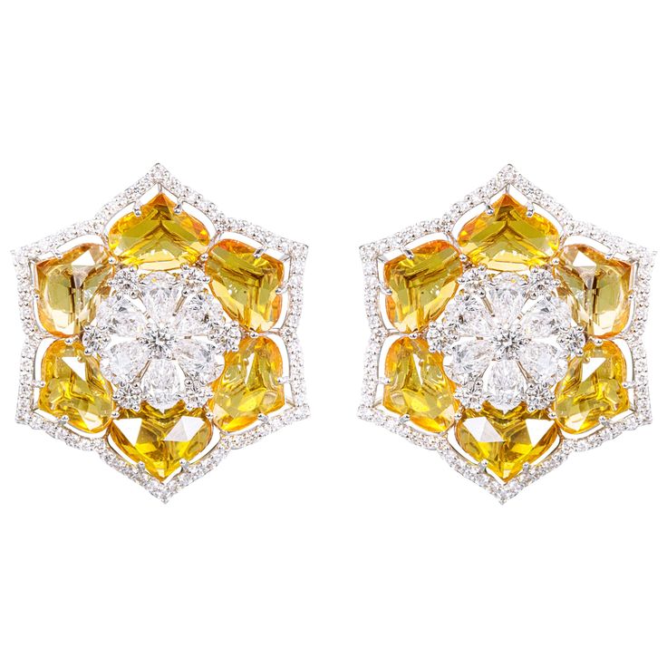 18 Karat Gold 20.50 Carats Sapphire and Diamond Flower Stud Earrings This special fancy rose cut vivid yellow sapphires and solitaire diamonds all layered together extraordinarily define the earring stud. The first layer forms an artistic flower with solitaire pear diamonds encompassing the flower with solitaire round diamonds placed in-between each pear diamond to glorify the look and warm the eyes, as the rest of the layers follow. The next layer is made of gracefully angled, identically matched and superbly fancy petal lotus cut yellow sapphires that are amicably surrounded by an umbrella layer of small pave diamonds to add more depth making the earring standout elegantly and defining luxury in every detail. It’s a magnificent modern stud earring with a sensational design and intricate Indian Wedding Jewelry, Pear Diamond, Diamond Flower, Flower Border, Flower Earrings Studs, Yellow Sapphire, Flower Studs, Sapphire Diamond, Diamond Solitaire