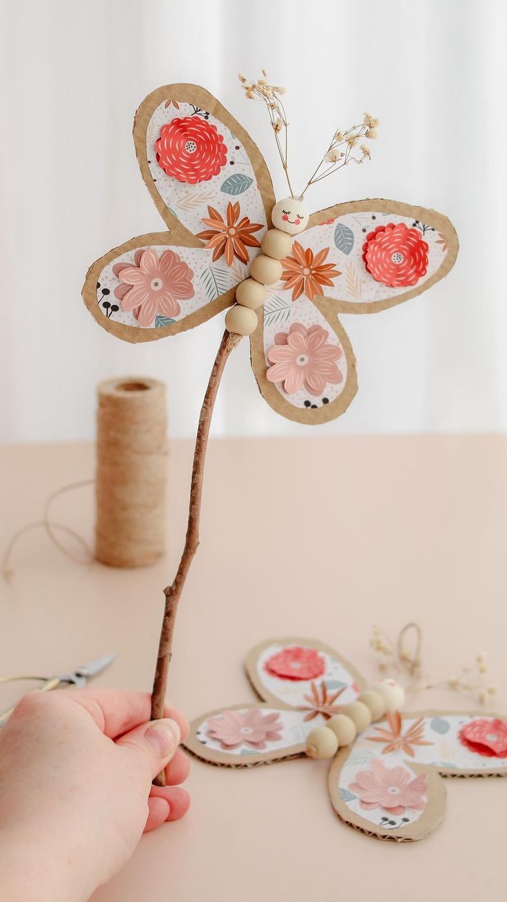 a person is working on some crafting with paper and wood flowers in the shape of butterfly wings