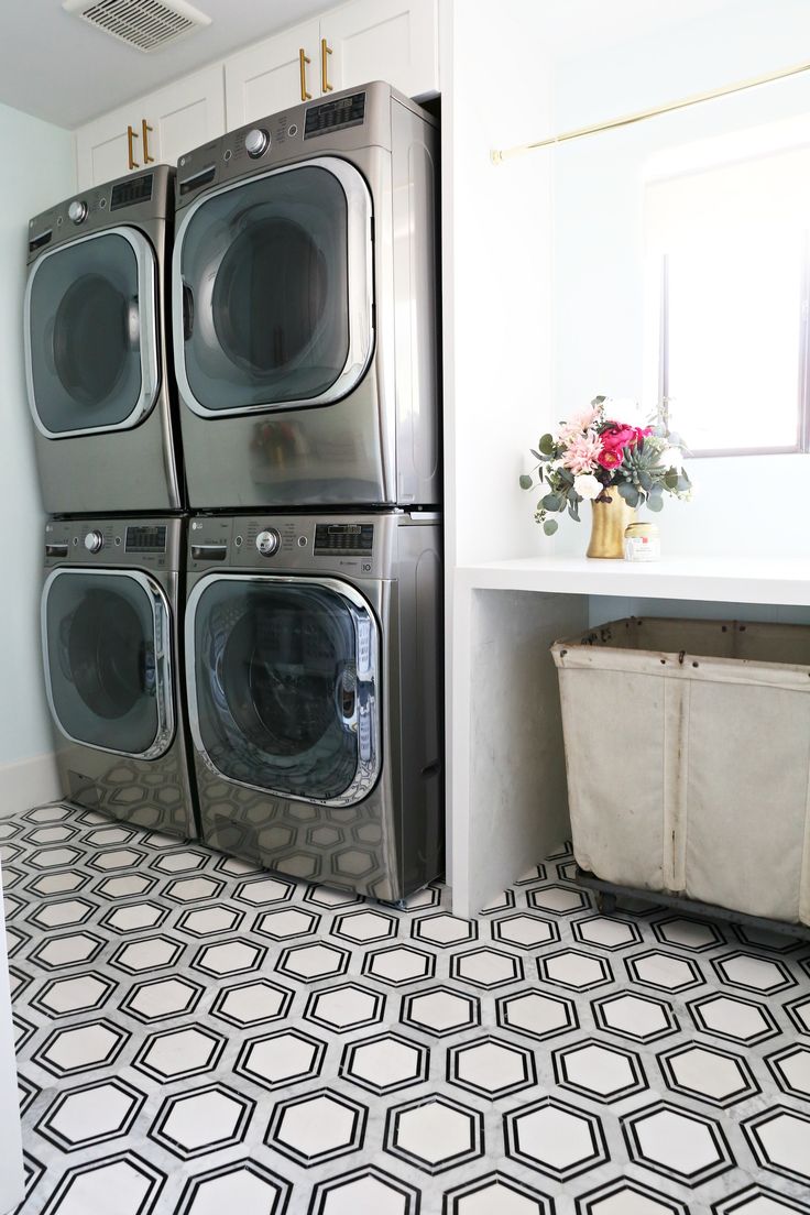 a washer and dryer in a room with black and white tile flooring