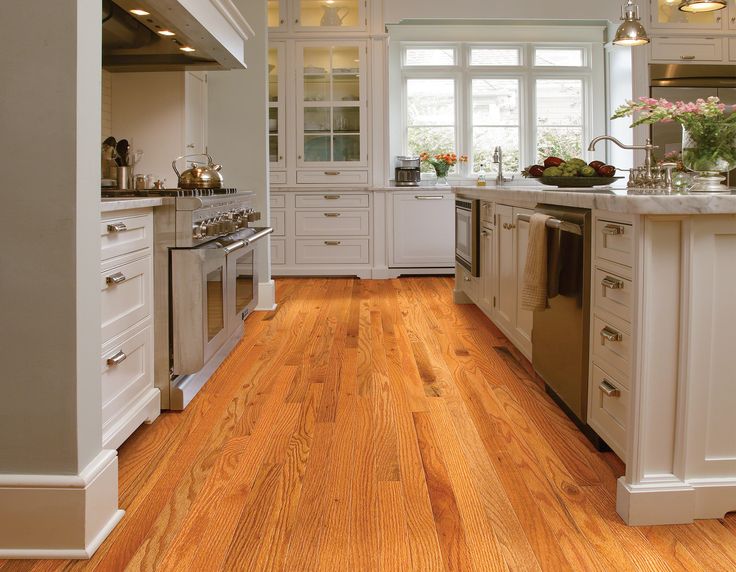 a kitchen with wood floors and white cabinets