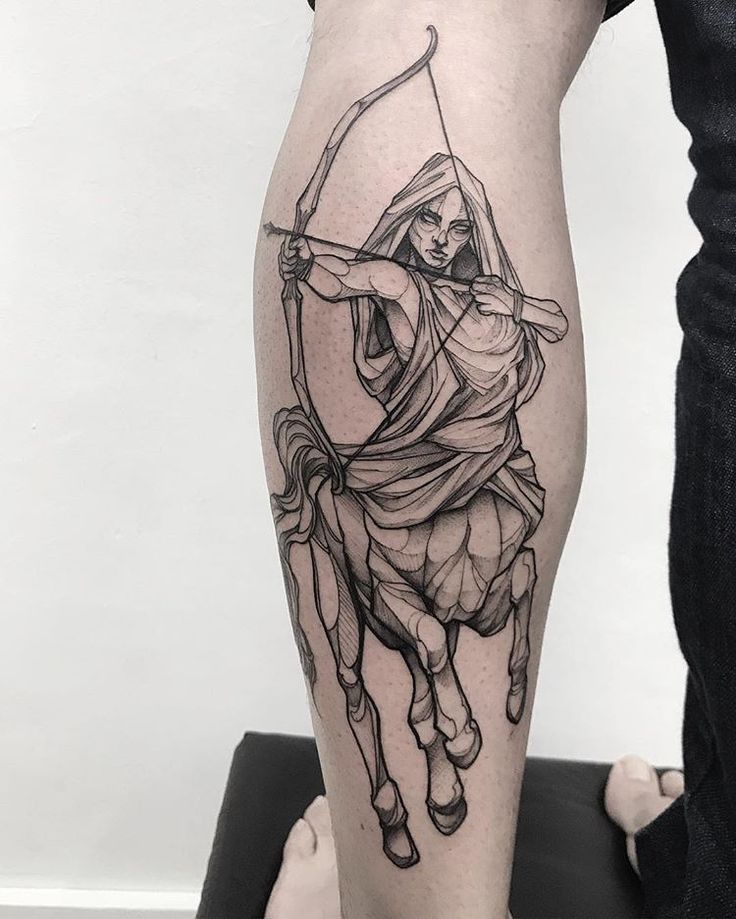 a man with a bow and arrow tattoo on his leg