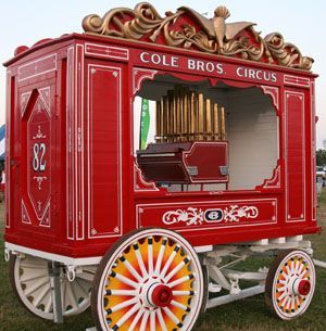 a red and yellow cart sitting on top of a lush green field