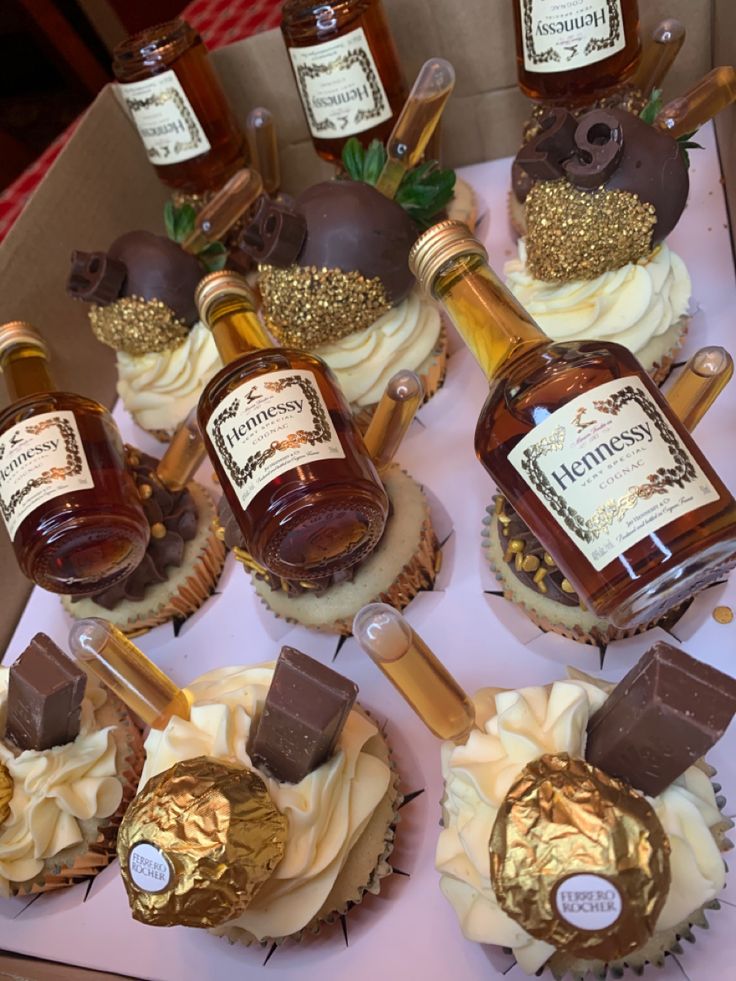 some cupcakes and bottles of whiskey on a table