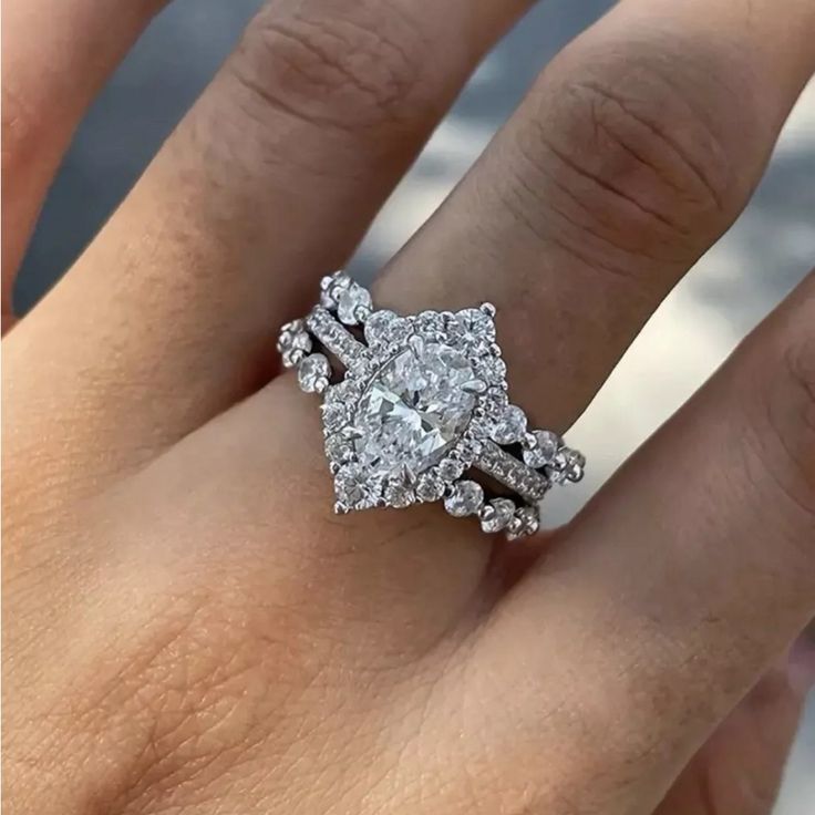 a woman's hand with a diamond ring on top of her finger, and the engagement