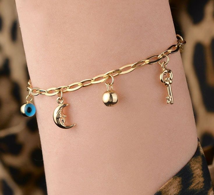 Our multi charm bracelet is 14k solid gold. Seven different charms are dangle on the paper clip chain of the bracelet. It has an anchor, lock&key, heart, evil eye, crescent moon, and gold ball. This charm bracelet will accompany you at any time of the day with its unique style. A round cut tiny white zircon stone is dangle on the end of the chain. If you consider this multi charm bracelet as a gift, it will make your loved ones happy on their birthdays, valentine's day, mother's day, anniversari Chain Bracelet With Charms, Gold Charm Bracelet With Moon Charm As A Gift, Gold Charm Bracelet With Symbolic Dangling Charms, Dangling Charms Chain Bracelet As Gift, Symbolic Charm Bracelet With Dangling Charms, Symbolic Dangle Charm Bracelet, Heart Paper Clip, Bracelet Lock, Key Heart