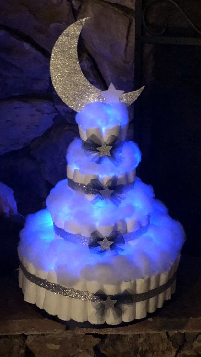 a three tiered cake with blue lights on it's sides and a crescent