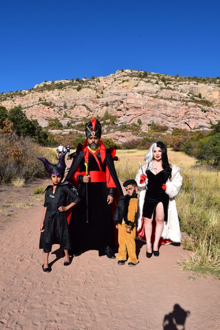 three people in costumes standing on a dirt path