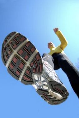 a person jumping up into the air with their feet in the air while wearing running shoes