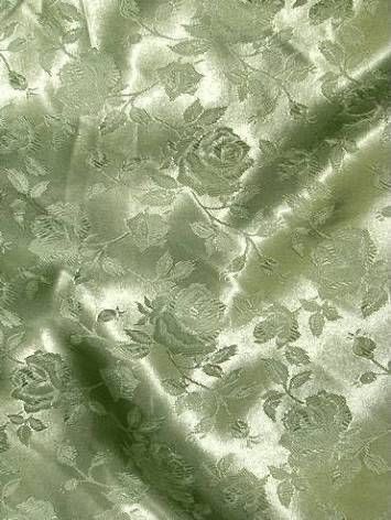 a close up view of the fabric with flowers and leaves on it, in light green