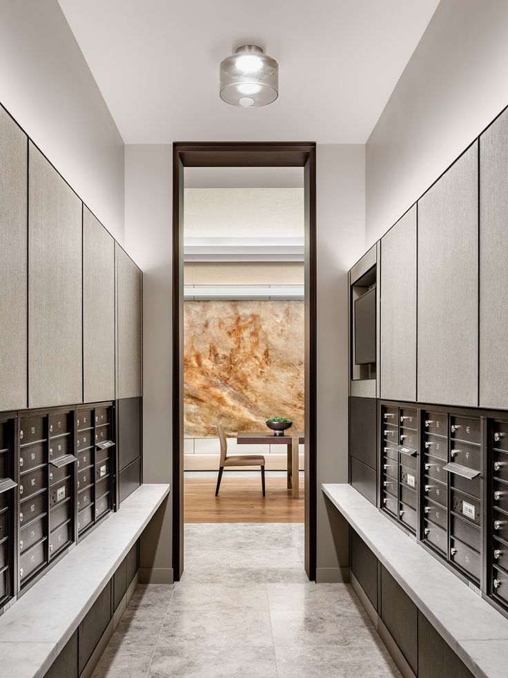 an empty room with many mail boxes on the wall and a table in the middle