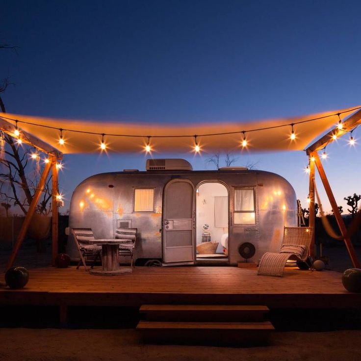 an airstream is lit up with string lights