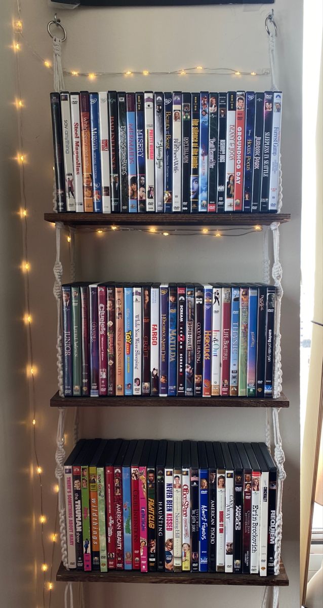 a shelf filled with lots of movies on top of a wall