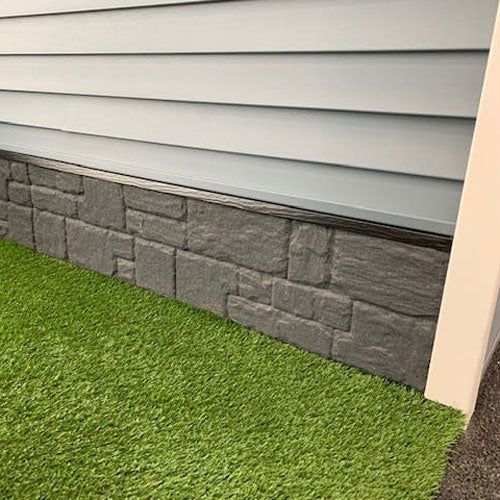 the grass is growing next to the house's front door, and it appears to be very green