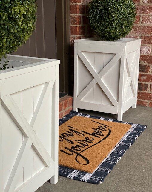 two white planters sitting next to each other on the side of a door way