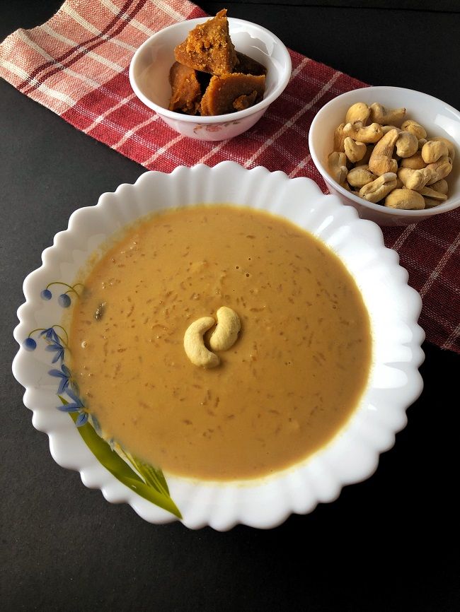 there is a bowl of soup and two bowls of nuts next to each other on the table