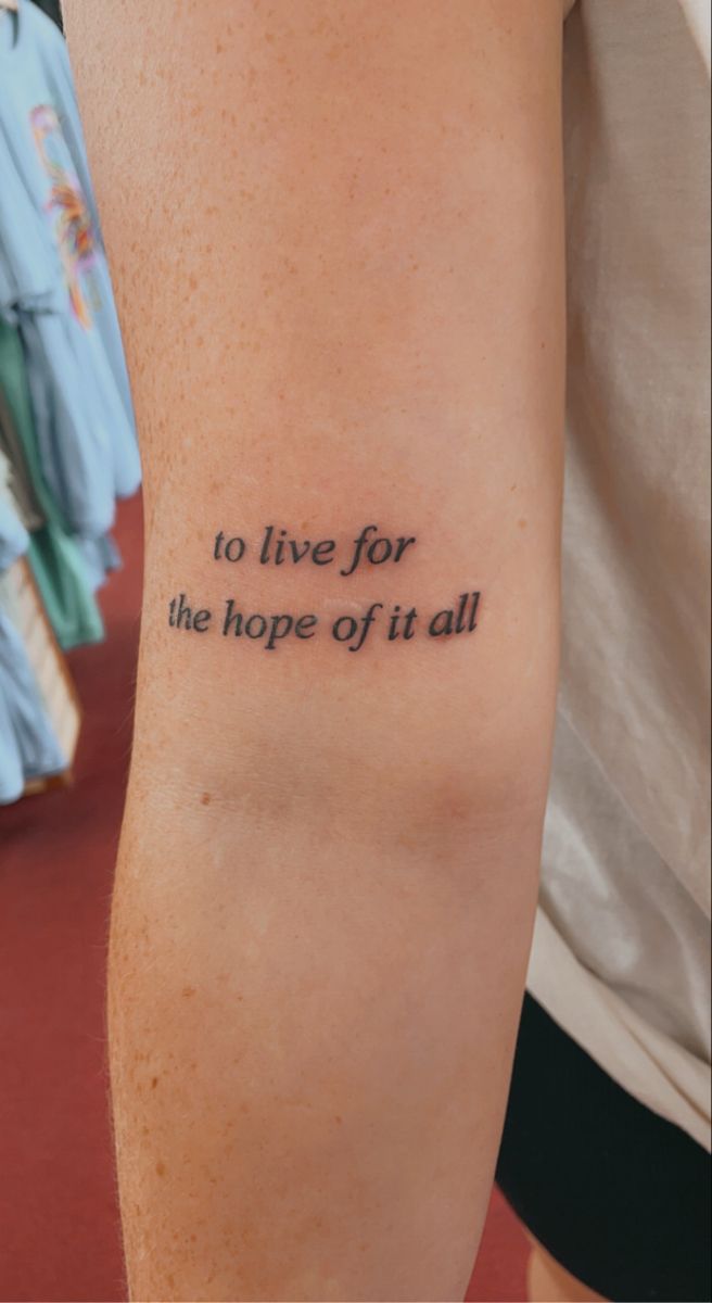 a person with a tattoo on their arm that says to live for the hope of it all