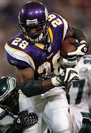 a football player running with the ball in his hands during a game against sports team