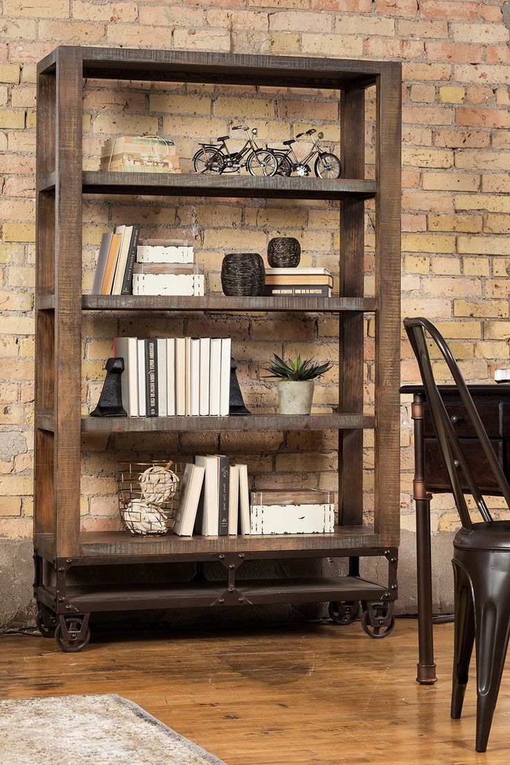 an old bookcase with many books on it in front of a brick wall and chair