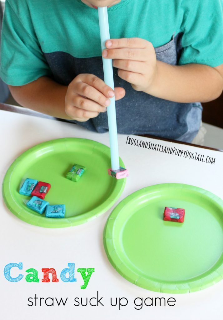 a young boy sitting at a table holding a blue toothbrush in front of two green plates with dices on them