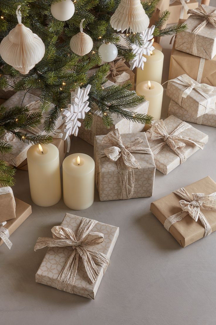 presents under the christmas tree with lit candles