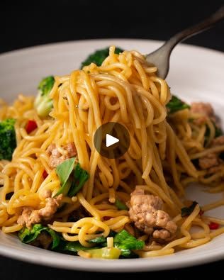 a white plate topped with pasta and broccoli next to a fork on top of it