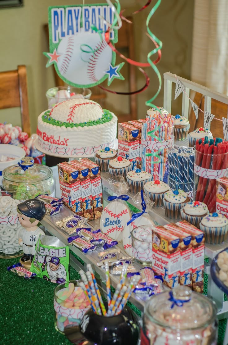 a baseball themed birthday party with cupcakes, candy and cake on the table