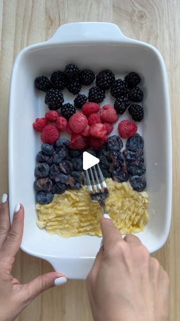 a person is eating some food with berries and pasta on it while holding a fork