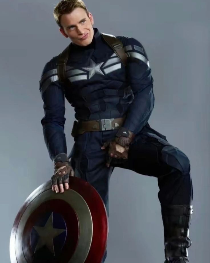 a man dressed as captain america holding a shield and posing with his hands on his hips