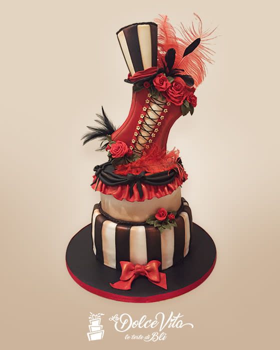 a cake that is sitting on top of a table with red and black decorations around it