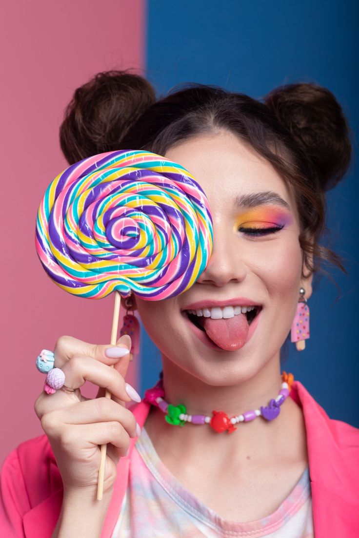 a woman holding a lollipop in front of her face