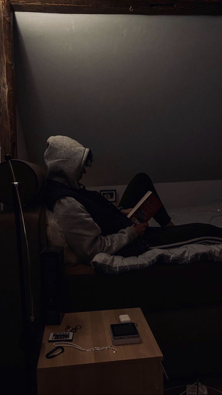 a person sitting on a bed reading a book