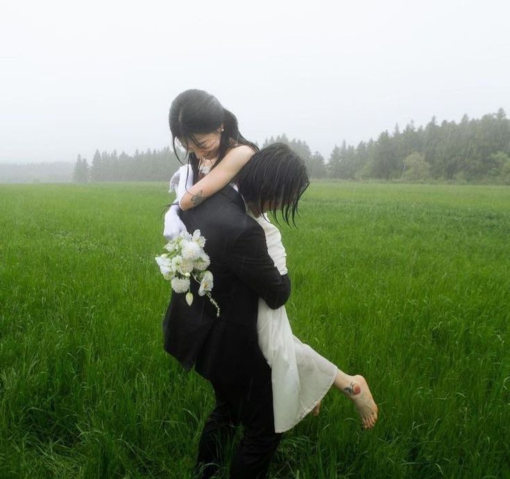 a woman holding a child in the middle of a field