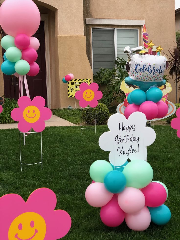 a birthday cake and balloons in the grass