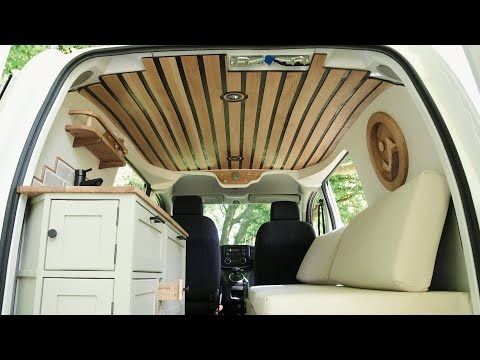 the interior of a van with wood trim and white leather seats is shown from the inside