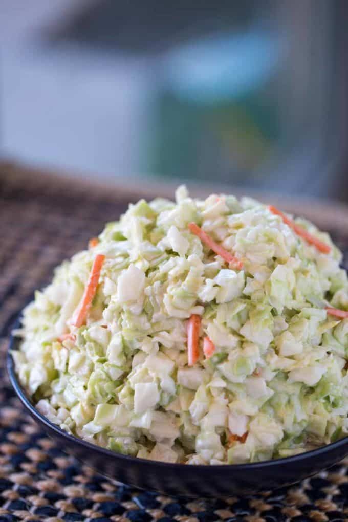 a bowl filled with coleslaw and carrots on top of a table