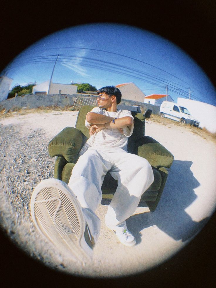 a man sitting in a lawn chair with his arms crossed and legs crossed while looking at the camera