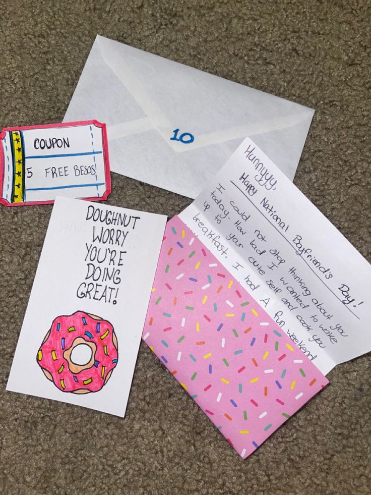 two envelopes with donuts and coupons are on the floor next to each other