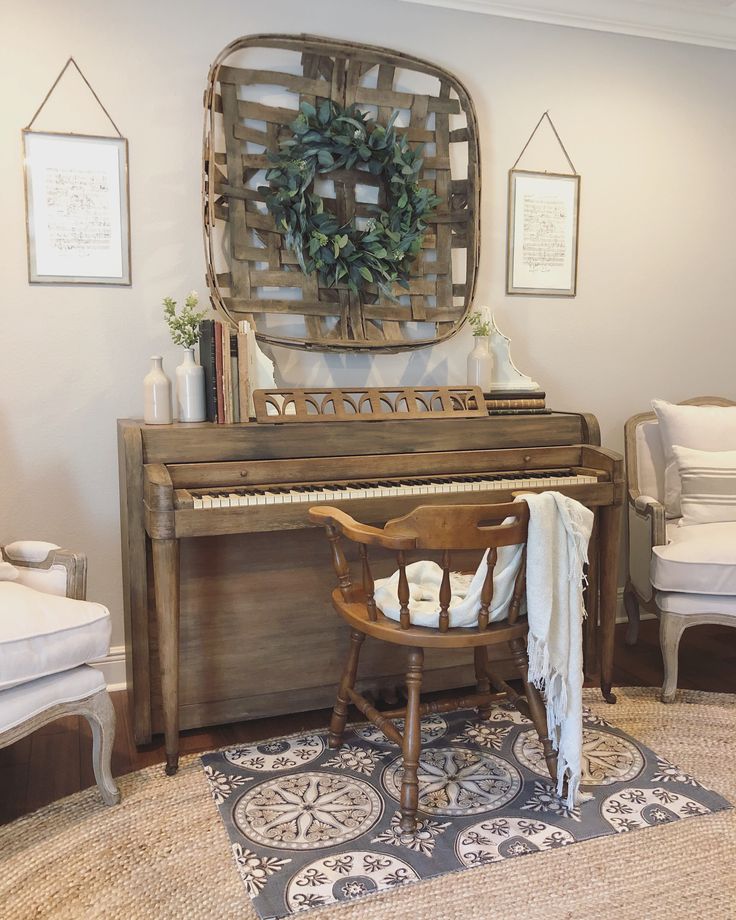 a living room filled with furniture and a grand piano in front of a wreath on the wall